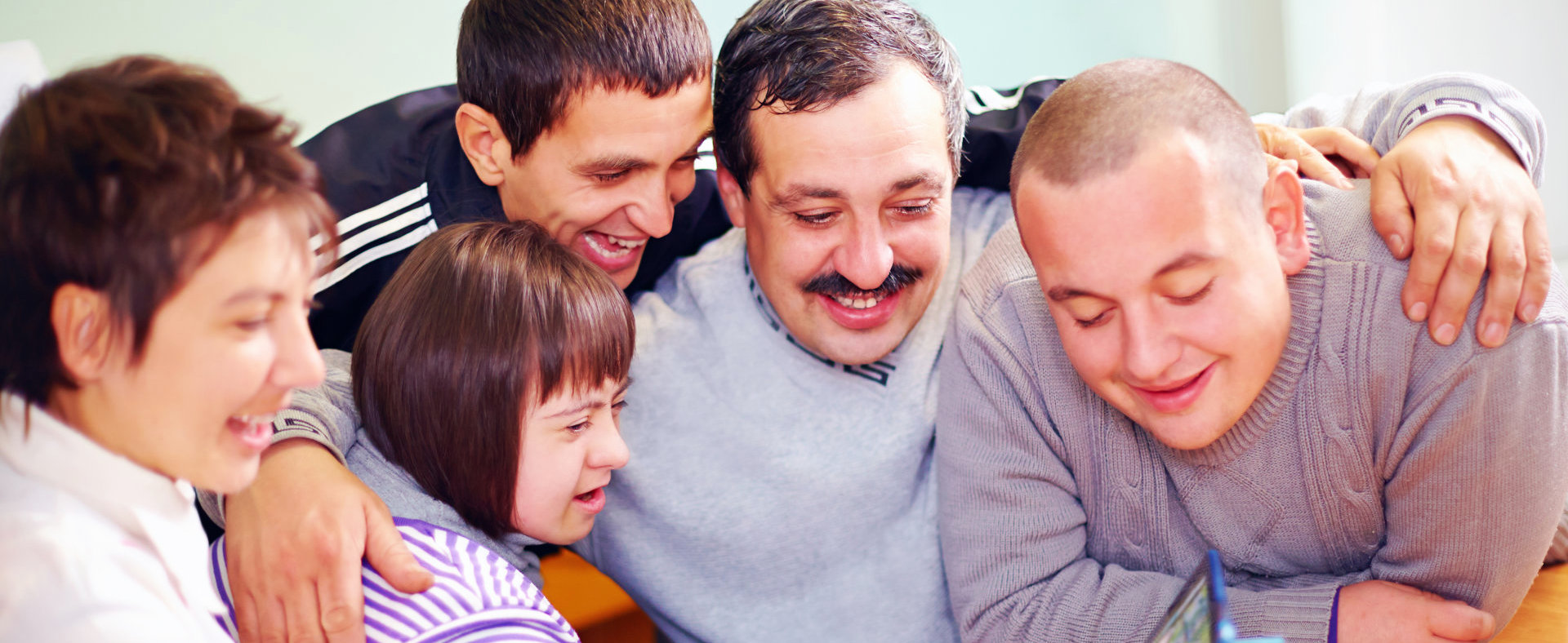 Happy people with disability having fun with a mobile tablet